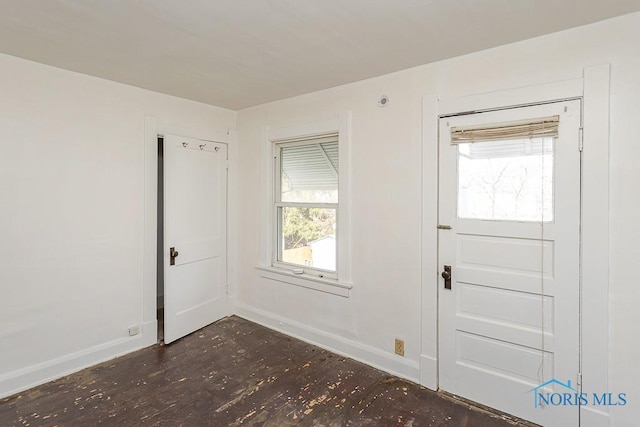 foyer entrance featuring baseboards and dark wood-type flooring