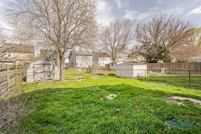 view of yard with a storage shed, an outdoor structure, and a fenced backyard