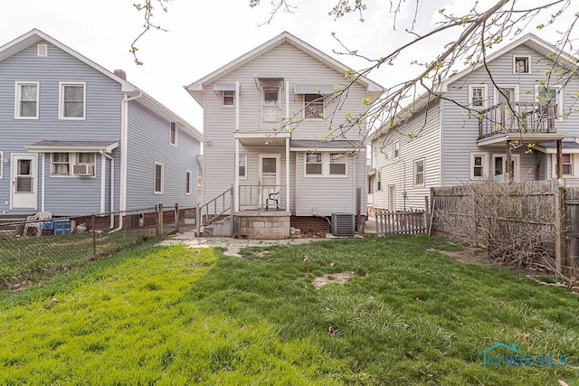 back of house featuring a yard, a fenced backyard, and central air condition unit