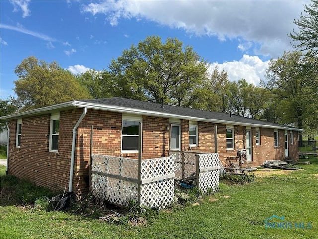 rear view of house with a yard and brick siding