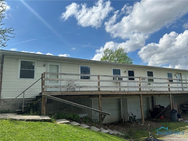 rear view of house with a deck and an attached garage