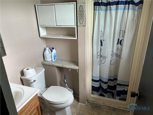 bathroom with toilet, vanity, and curtained shower