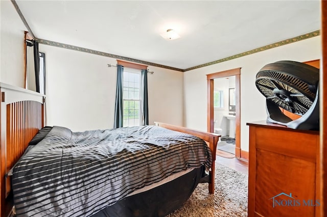 bedroom featuring connected bathroom and wood finished floors