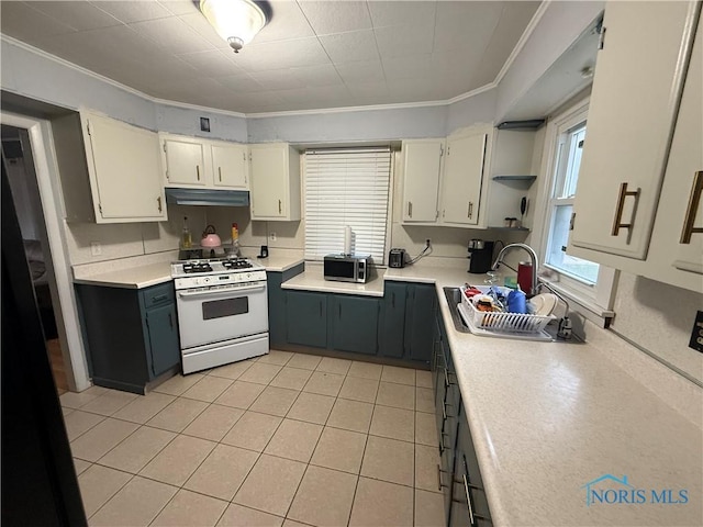 kitchen featuring white gas range, stainless steel microwave, under cabinet range hood, light countertops, and ornamental molding