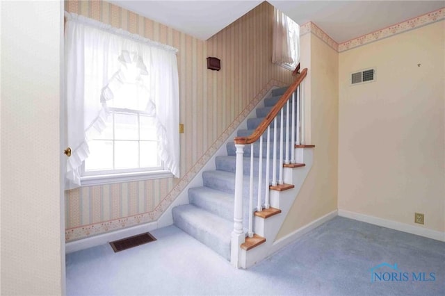 stairway featuring wallpapered walls, visible vents, and carpet floors