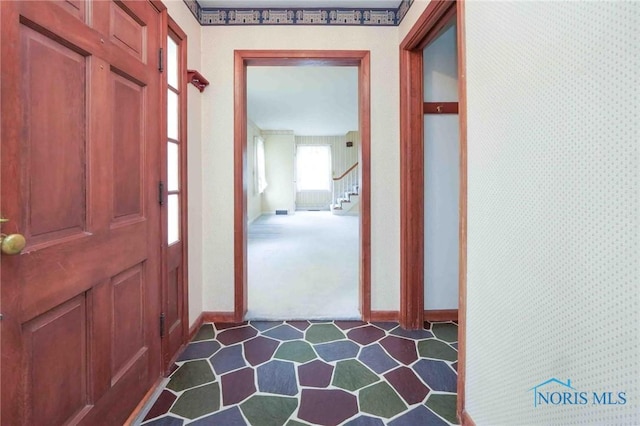 interior space with baseboards and stairs