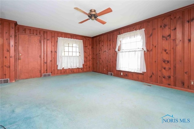spare room with a wealth of natural light, carpet flooring, ceiling fan, and visible vents