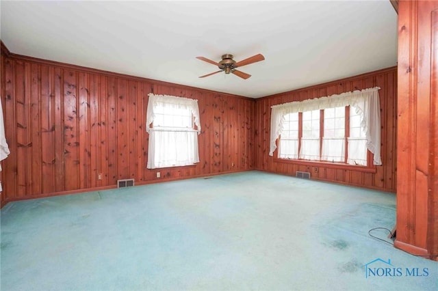 unfurnished room with carpet, a ceiling fan, and visible vents