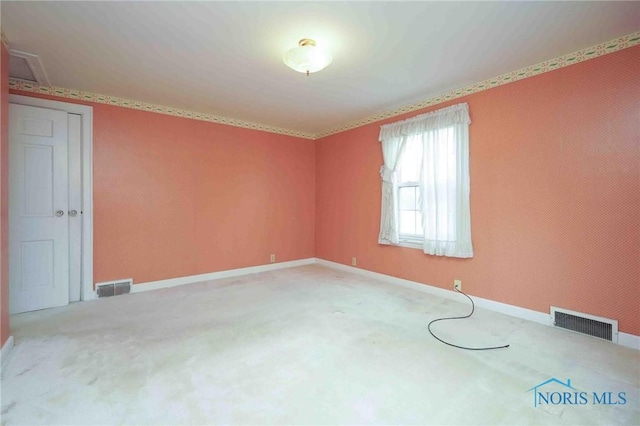 spare room with visible vents, baseboards, and carpet floors