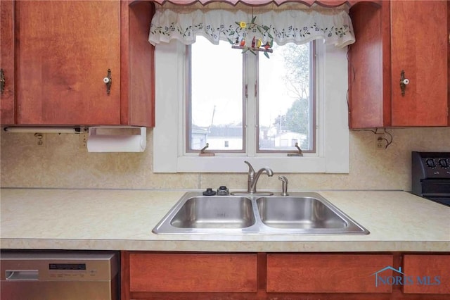 kitchen with dishwashing machine, a healthy amount of sunlight, light countertops, and a sink