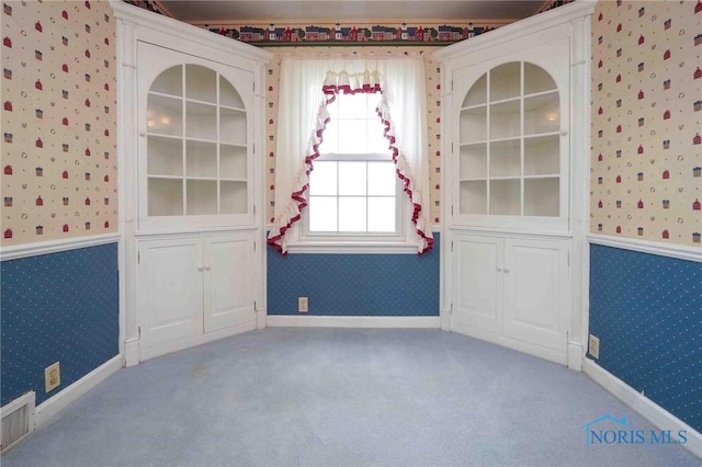 carpeted spare room featuring wallpapered walls and visible vents