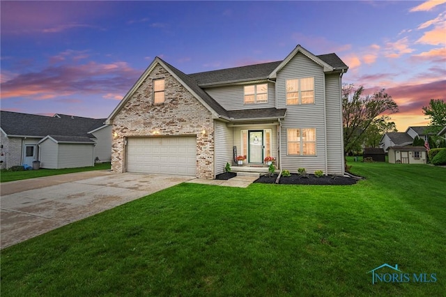 traditional home with a lawn, an attached garage, brick siding, and driveway