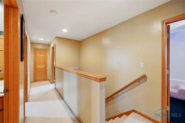 corridor featuring carpet flooring, an upstairs landing, and recessed lighting