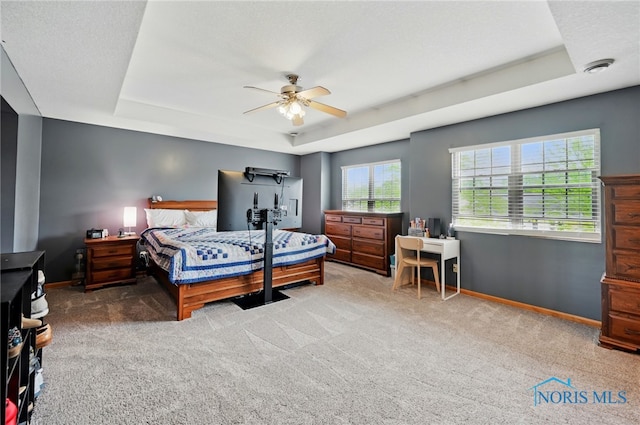 bedroom with baseboards, a tray ceiling, a ceiling fan, and carpet floors