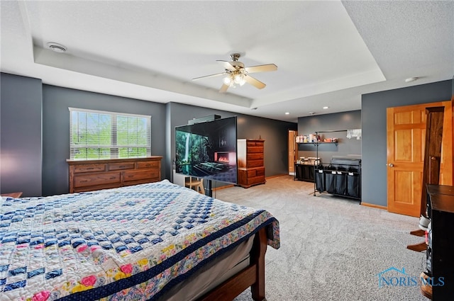 bedroom with light carpet, a raised ceiling, baseboards, and recessed lighting