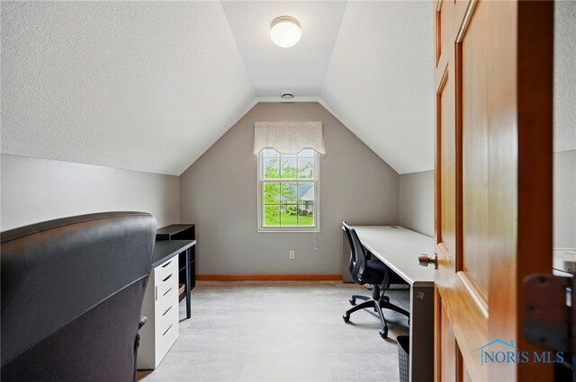 office with lofted ceiling and baseboards