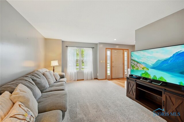 living area with baseboards, light carpet, and recessed lighting