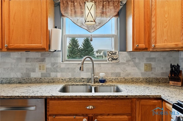 kitchen with brown cabinets, stove, a sink, and dishwasher