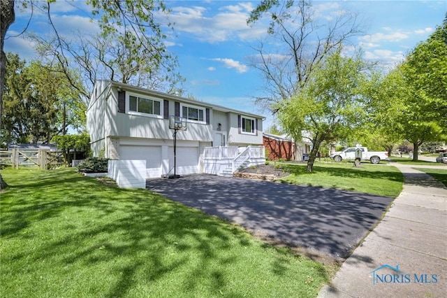 250 Southwood Dr, Perrysburg, OH 43551 - split foyer home featuring aphalt driveway, fence, an attached garage, and a front yard