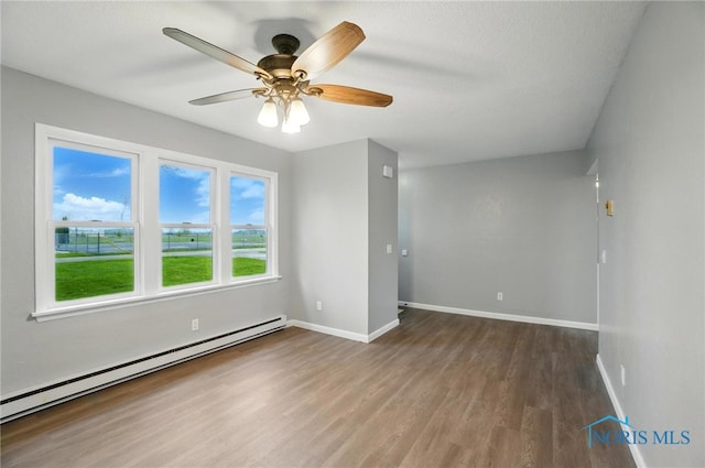 20161 Locust St, Weston, OH 43569 - unfurnished room with a baseboard heating unit, baseboards, ceiling fan, and wood finished floors