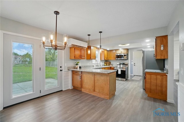 20161 Locust St, Weston, OH 43569 - kitchen featuring a peninsula, brown cabinets, light wood-style flooring, stainless steel appliances, and a notable chandelier