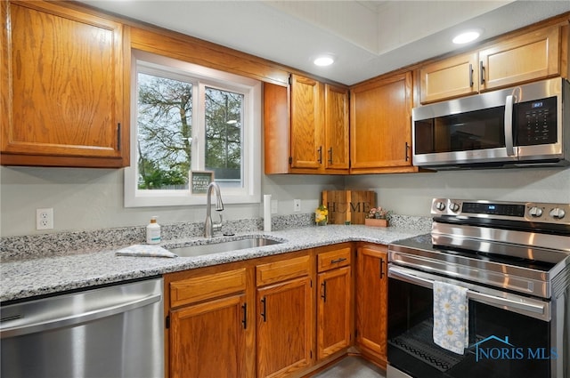 20161 Locust St, Weston, OH 43569 - kitchen with recessed lighting, brown cabinetry, light stone counters, a sink, and stainless steel appliances