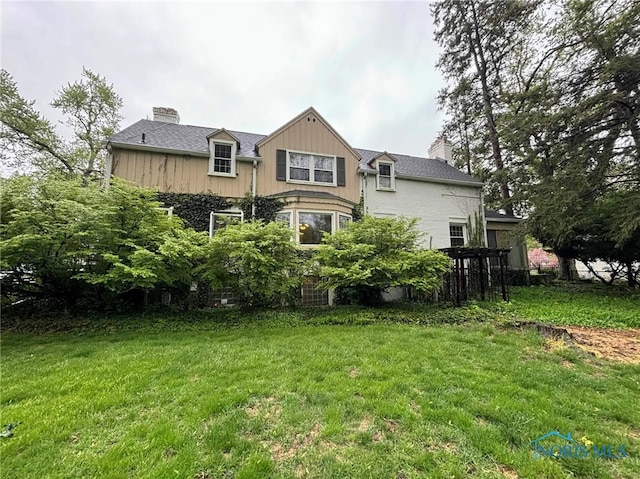 back of property featuring a yard and a chimney