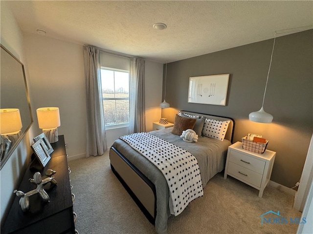 bedroom with a textured ceiling, baseboards, and carpet