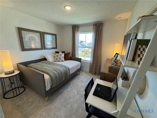 bedroom featuring a textured ceiling and carpet flooring