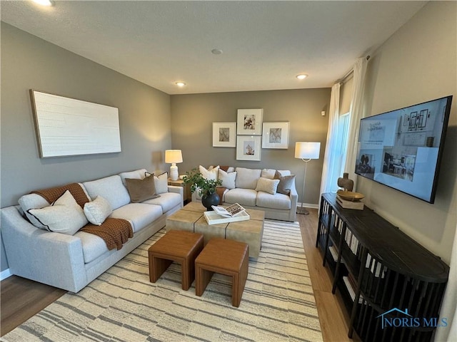living area with light wood-style floors, baseboards, and recessed lighting