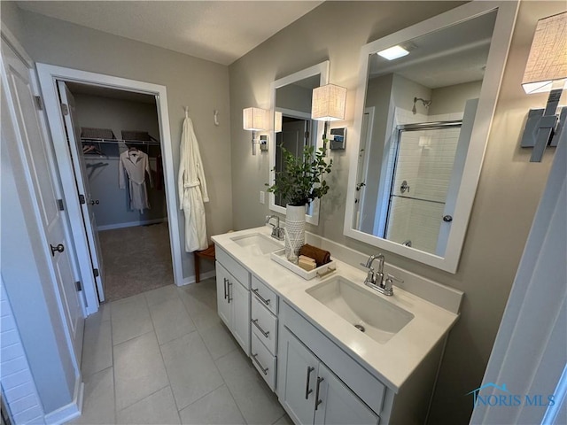 full bathroom with a stall shower, double vanity, a sink, and a walk in closet