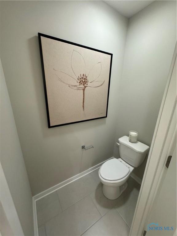 bathroom with baseboards, tile patterned flooring, and toilet