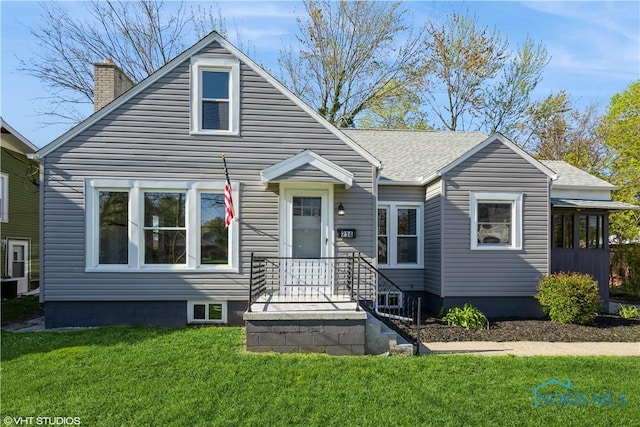 214 Meekison St, Napoleon, OH 43545 - bungalow-style home featuring a chimney, a front yard, and a shingled roof