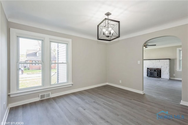 214 Meekison St, Napoleon, OH 43545 - unfurnished dining area featuring baseboards, dark wood finished floors, visible vents, and ceiling fan with notable chandelier