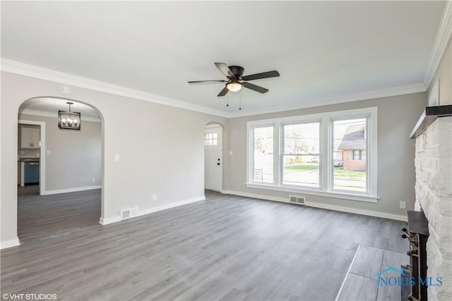 214 Meekison St, Napoleon, OH 43545 - unfurnished living room featuring wood finished floors, ceiling fan with notable chandelier, visible vents, baseboards, and arched walkways