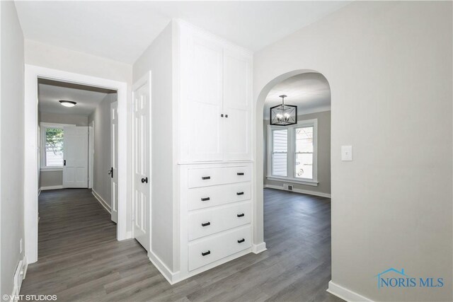 214 Meekison St, Napoleon, OH 43545 - hall with an inviting chandelier, arched walkways, baseboards, and wood finished floors