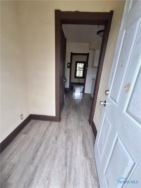 hallway with light wood finished floors and baseboards