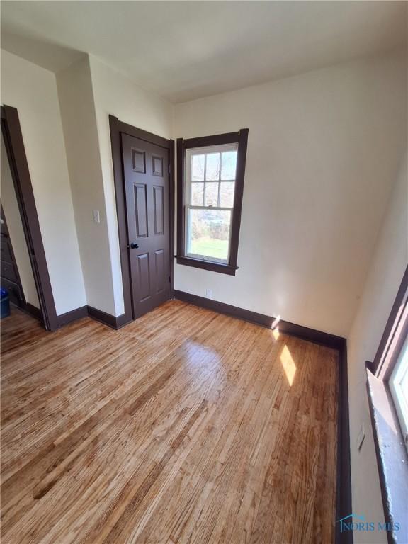 empty room featuring baseboards and light wood-style flooring