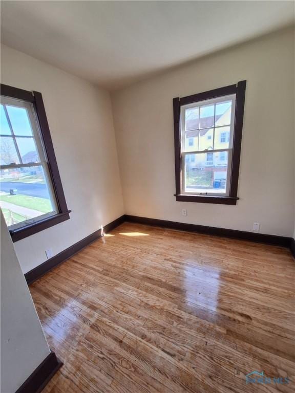 empty room featuring baseboards and wood finished floors