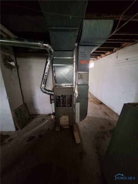 unfinished basement featuring heating unit