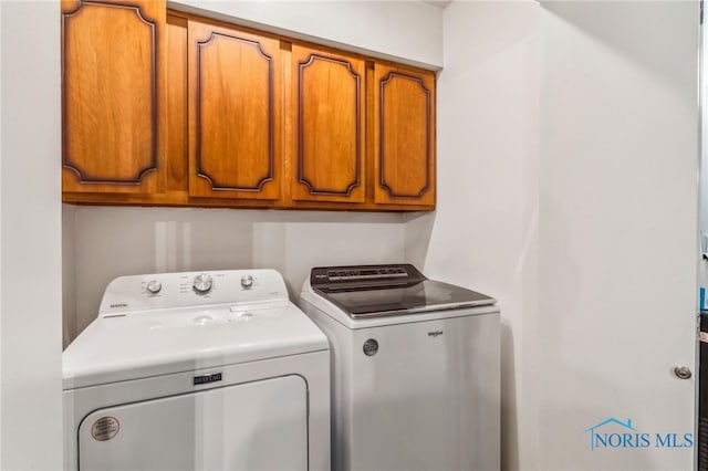 washroom with cabinet space and washing machine and dryer
