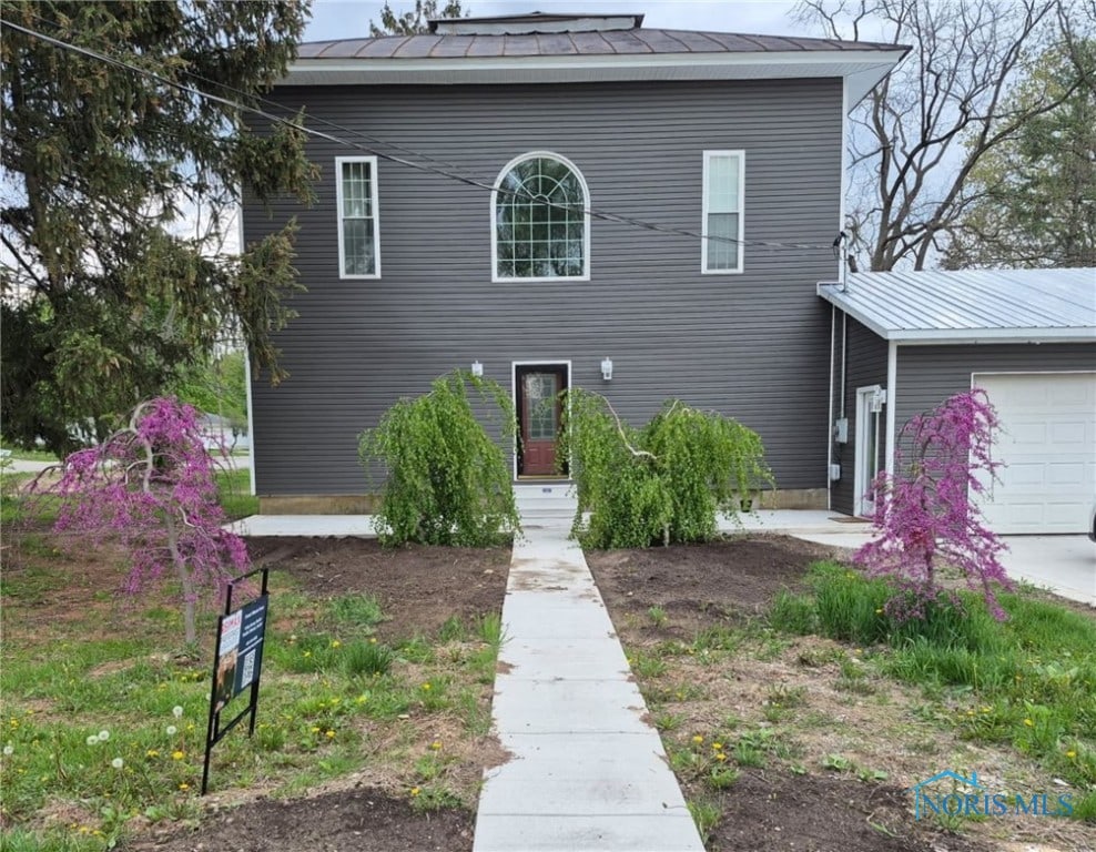 view of front facade featuring a garage and metal roof