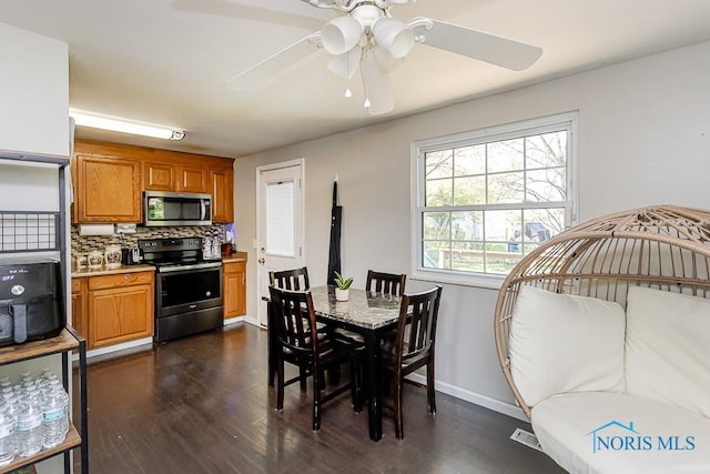 dining room with dark wood-style floors, a ceiling fan, and baseboards
