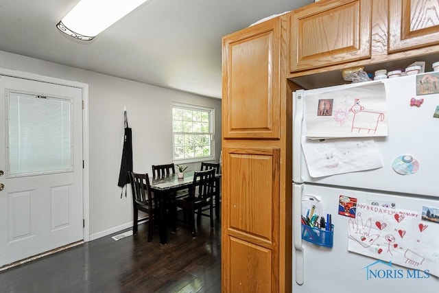 kitchen featuring freestanding refrigerator, dark wood-type flooring, and baseboards