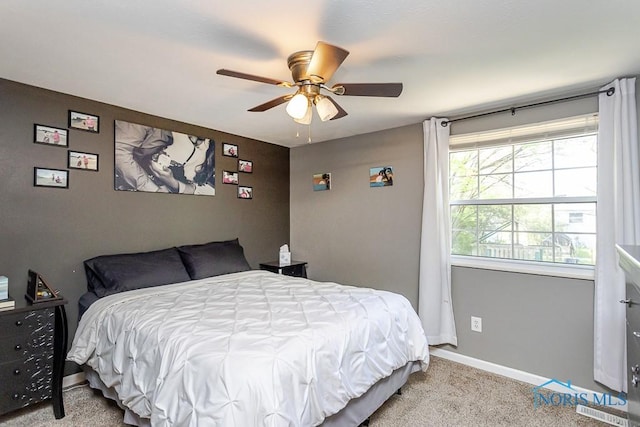 carpeted bedroom with baseboards and a ceiling fan