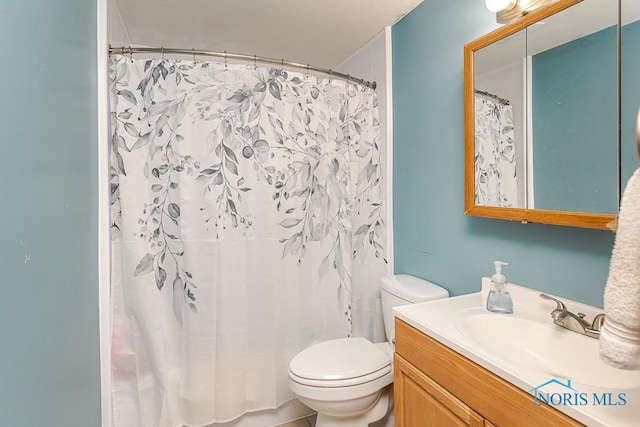 full bathroom with toilet, vanity, and curtained shower