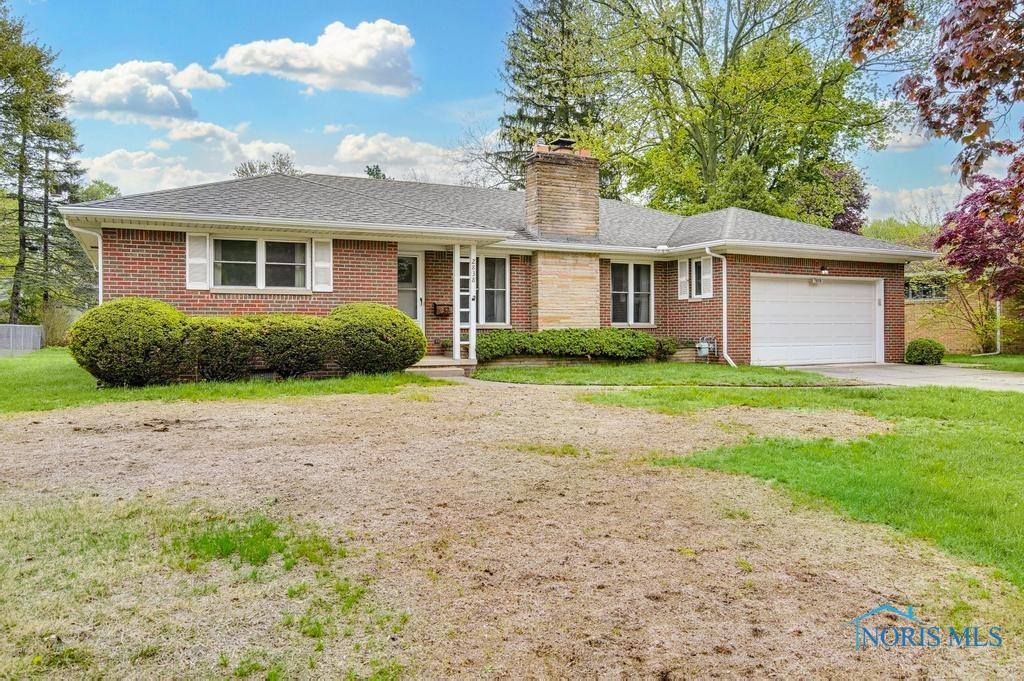 2838 Isha Laye Way, Toledo, OH 43606 - ranch-style home featuring a garage, brick siding, a chimney, a front lawn, and concrete driveway