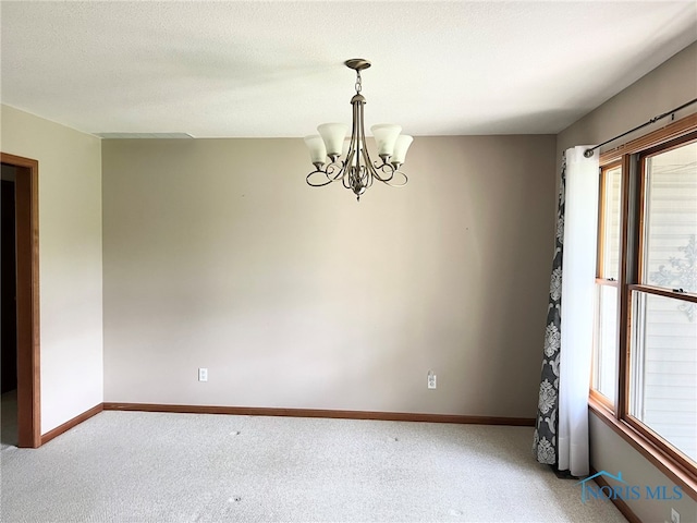 844 Sunset Dr, Findlay, OH 45840 - empty room featuring a chandelier, light carpet, and baseboards