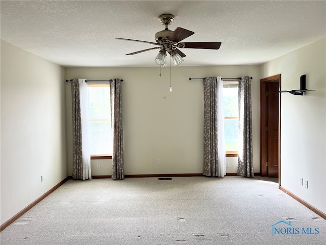 844 Sunset Dr, Findlay, OH 45840 - carpeted spare room featuring ceiling fan, baseboards, and a textured ceiling