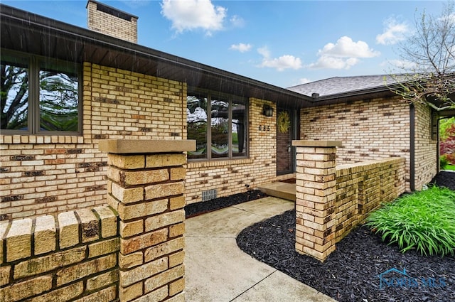 685 N Main St, Arlington, OH 45814 - view of exterior entry featuring brick siding and a chimney